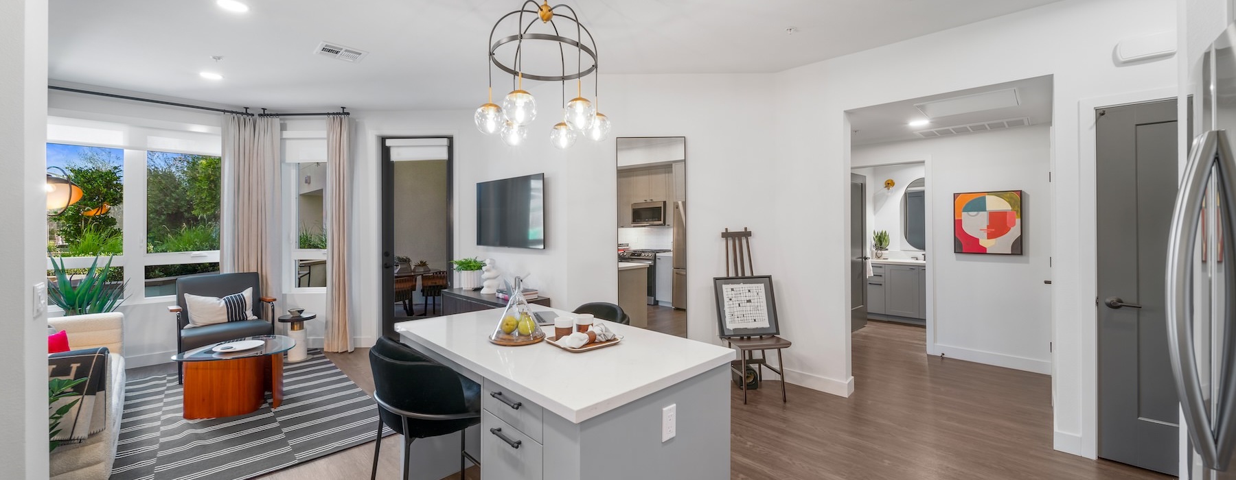 a large kitchen with an island and a living room with a large window
