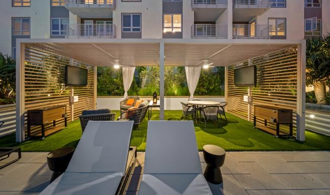 a patio with tables and chairs and a building in the background